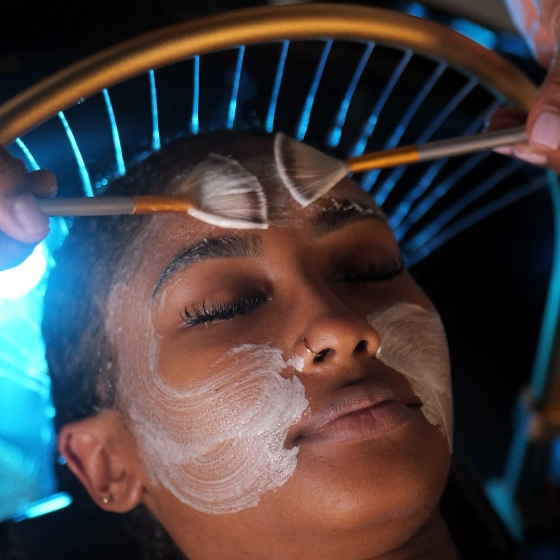 YNAO HEAD SPA GUADELOUPE-TOUS DROITS RESERVES Femme allongée avec un bandeau sur les yeux, recevant un soin au spa.