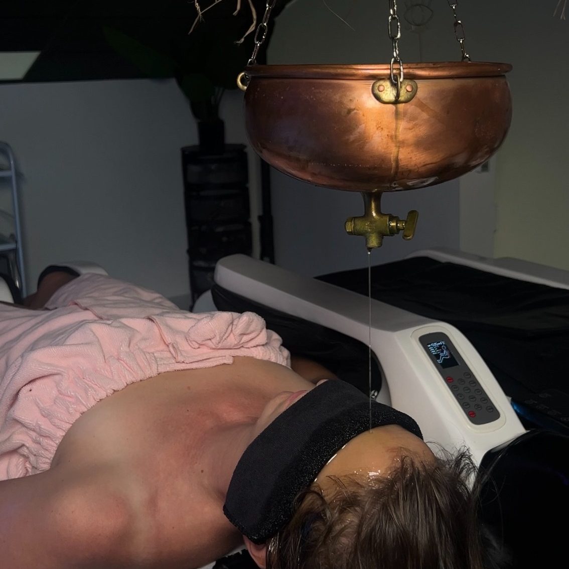 YNAO HEAD SPA GUADELOUPE-TOUS DROITS RESERVES Femme allongée avec un bandeau sur les yeux, recevant un soin au spa.
